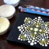this is the image of a dot painted mandala with dotting tools and acrylic pots