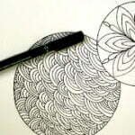 this is the image of a mandala and a zentangle sketched on an A4 paper with a pen on its side
