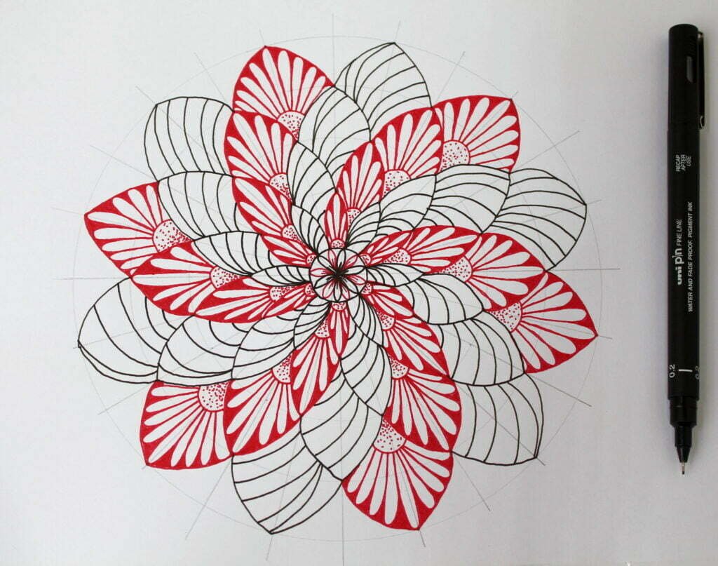 this is the image of a two colored mandala drawn on a white a4 paper with fine black pen