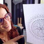 this is the image of a woman holding a mandala sketch