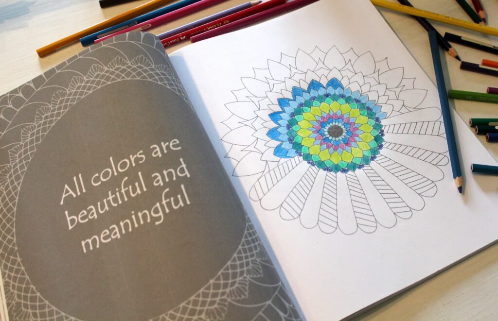 a mandala coloring book with a mandala design partially colored. On the opposite page there's the sentence "All colors are beautiful and meaningful"