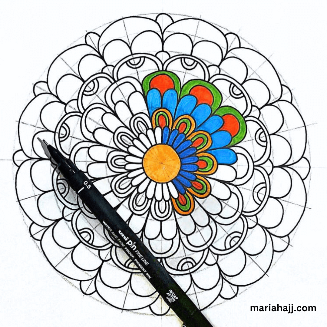 a partially colored mandala with a drawing pen in its center